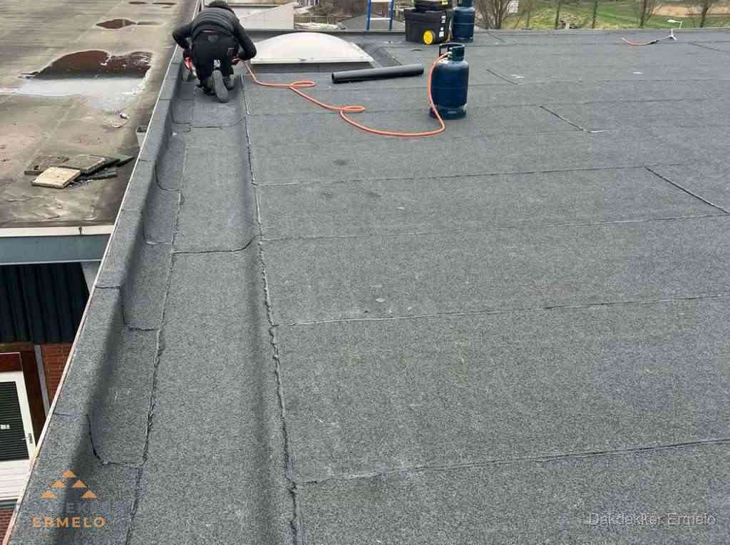Dakdekker repareert bitumen dakbedekking op groot plat dak in Ermelo Dakdekker repareert bitumen dakbedekking op groot plat dak in Ermelo